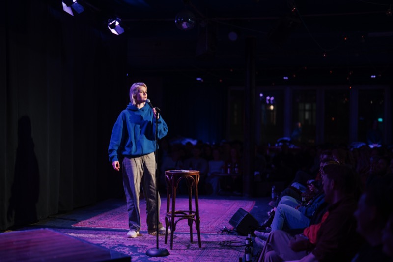 Comedienne auf der Bühne im Clublicht