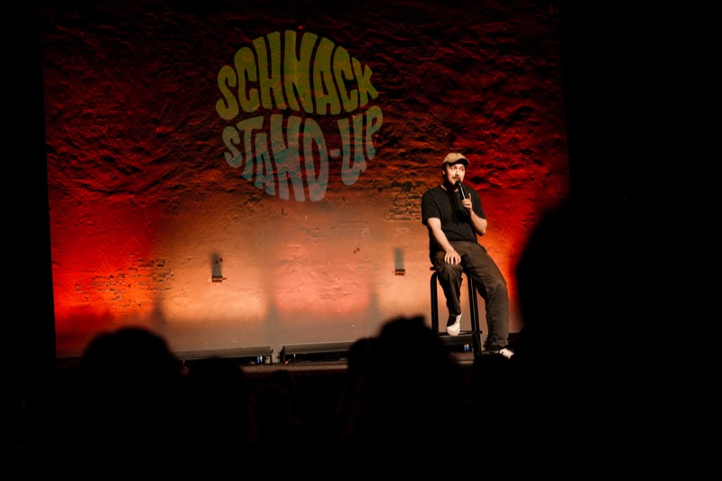 Comedian auf der Bühne vor der SCHNACK Stand-Up Wand